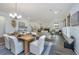 Open concept dining area with wooden table and chairs, adjacent to living room and kitchen at 15 Darby Meadow Ln, Ridgeville, SC 29472