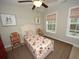 Cozy bedroom with floral bedding, two windows and red and white chairs at 420 Eagleview Dr, Moncks Corner, SC 29461
