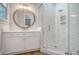 Bathroom with white vanity, marble shower, and circular mirror at 19 Bradley Pasture Way, Ravenel, SC 29470