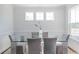 Bright dining room with glass table and gray chairs, hardwood floors at 1165 Oak Bluff Ave, Charleston, SC 29492