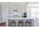Modern kitchen features a large island with seating, white cabinets, and stainless steel appliances at 1165 Oak Bluff Ave, Charleston, SC 29492