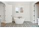Modern bathroom with freestanding tub, decorative floor tiles, and white walls at 3820 Gnarled Oaks Ln, Johns Island, SC 29455
