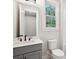 Modern bathroom with a gray vanity, white toilet, and window at 3820 Gnarled Oaks Ln, Johns Island, SC 29455