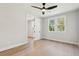 Empty bedroom with hardwood floors, a ceiling fan, two windows, and an open door at 3820 Gnarled Oaks Ln, Johns Island, SC 29455