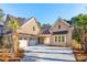 Side view of a two-story brick home featuring a porte-cochère and a two-car garage at 3820 Gnarled Oaks Ln, Johns Island, SC 29455