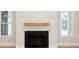 Modern fireplace with a wooden mantel and black hearth in a bright living room at 3820 Gnarled Oaks Ln, Johns Island, SC 29455