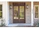 Elegant double wooden front doors on a brick home with glass panels and sidelights at 3820 Gnarled Oaks Ln, Johns Island, SC 29455