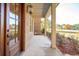 Covered front porch with brick exterior and wooden front door at 3820 Gnarled Oaks Ln, Johns Island, SC 29455
