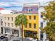 Aerial view of yellow 3 story building on tree lined street at 29 Broad St # B, Charleston, SC 29401