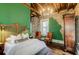Charming bedroom with green walls, exposed brick, and hardwood floors at 29 Broad St # B, Charleston, SC 29401