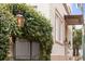 Exterior view of building with lush greenery, iron gate, and lit lanterns at 85 Cumberland St # P2, Charleston, SC 29401