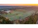 Aerial view of farm fields and surrounding woodlands at sunrise at 6500 Parkers Ferry Rd, Adams Run, SC 29426
