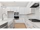Modern white kitchen with large island and stainless steel appliances at 1153 Oak Bluff Ave, Charleston, SC 29492