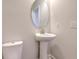 Small bathroom with pedestal sink, oval mirror, and toilet at 2000 Winding Grove Ln, Moncks Corner, SC 29461