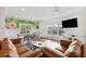 Spacious living room with leather sofas, a large TV, and a tropical-themed wall mural at 7 33Rd Ave, Isle of Palms, SC 29451