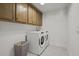 Laundry room with wooden cabinets and white washer and dryer at 374 Wappoo Trace Ln, Summerville, SC 29486