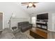 Living room features grey couches, a large TV, and a ceiling fan at 8217 Little Sydneys Way, North Charleston, SC 29406