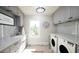 Bright laundry room with gray cabinets, quartz countertops, and hexagon tile floor at 34 Waterway Island Dr, Isle of Palms, SC 29451