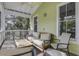 Screened porch with comfy seating, ceiling fan, and treetop views at 614 E Cooper Ave, Folly Beach, SC 29439