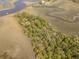 Aerial view of a private island with house, dock, and lush vegetation at 8871 Palmetto Rd # 33 Ac Private Island, Edisto Beach, SC 29438