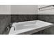 White bathtub with dark tile surround at 5565 Colonial Chatsworth Cir, North Charleston, SC 29418
