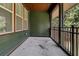 Screened porch with wood railing and view of trees at 5565 Colonial Chatsworth Cir, North Charleston, SC 29418