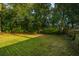 Large backyard with mature trees and a wooden fence at 520 Woodland Shores Rd, Charleston, SC 29412