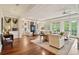 Spacious living room with hardwood floors, large windows, and access to a private balcony at 5 Middle Atlantic Wharf # 3A, Charleston, SC 29401