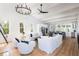 Open living area with white sofas, high ceilings, and a chandelier at 403 Pelican Flight Dr, Dewees Island, SC 29451