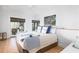 Bright bedroom with queen bed, access to a deck, and light wood floors at 403 Pelican Flight Dr, Dewees Island, SC 29451