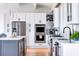 Modern kitchen boasts white cabinets, stainless steel appliances, and a large island at 403 Pelican Flight Dr, Dewees Island, SC 29451