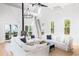 Bright and airy living room with white sofas, hardwood floors, and a fireplace at 403 Pelican Flight Dr, Dewees Island, SC 29451