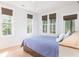 Bedroom with queen bed and multiple windows, light wood floors at 403 Pelican Flight Dr, Dewees Island, SC 29451