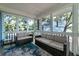 Relaxing screened porch with wicker furniture and blue rug, overlooking wooded area at 2221 Oyster Catcher Ct, Seabrook Island, SC 29455