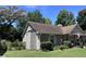Brick ranch home with mature landscaping and American flag at 4504 Winterwood Pl, Ladson, SC 29456