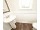Stylish powder room features pedestal sink, dark wood-look floors, and decorative mirror at 508 Eagleview Dr, Moncks Corner, SC 29461