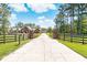 Long driveway leading to a brick home with black fence at 1426 Sc-45, McClellanville, SC 29458