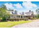 Brick and white two-story home with large front porch and landscaped yard at 1426 Sc-45, McClellanville, SC 29458