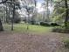 Large backyard with sparse leaves and distant home at 138 Waddell Ln, Ridgeville, SC 29472