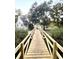 Charming wooden bridge leading to a two-story home at 138 Waddell Ln, Ridgeville, SC 29472