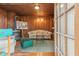 Living room with wood paneling, wood floors, and vintage furniture near door at 712 W Ashley Ave, Folly Beach, SC 29439