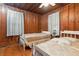 Two twin beds in a spacious bedroom with wood walls and flooring at 712 W Ashley Ave, Folly Beach, SC 29439