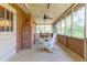 Relaxing screened porch with brick fireplace and seating at 712 W Ashley Ave, Folly Beach, SC 29439