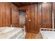 Two beds in a room with wood walls and hardwood floors at 712 W Ashley Ave, Folly Beach, SC 29439