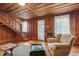 Living room with wood paneling, staircase, and vintage furniture at 712 W Ashley Ave, Folly Beach, SC 29439