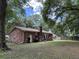 Spacious backyard with large trees and a brick house at 1056 Yorktown Dr, Charleston, SC 29412