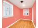 Bright bedroom with coral walls and hardwood floors at 118 E Ashley And 110 E Cooper Ave Ave, Folly Beach, SC 29439