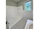 Bright bathroom with a white bathtub and marble-look tiled floors at 401 Constance St, Walterboro, SC 29488
