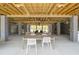 Long community patio table with white chairs under wooden beams at 1698 Cultivation Ln # 541, Mount Pleasant, SC 29466