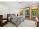 Bright bedroom with striped bedding, large windows, and a view of lush greenery at 3067 Marshgate Dr, Seabrook Island, SC 29455